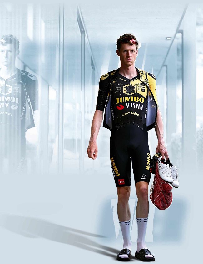 Nathan Van Hooydonck in Jumbo-Visma kit holding cycling shoes