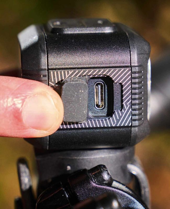 Close-up of USB-C charging port on bike light with finger