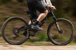 Close-up motion blur of rider on black full-suspension mountain bike