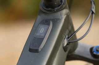 Close-up of e-bike control unit mounted on dark green frame