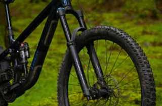 Close-up of muddy fork, wheel and tyre on full-suspension MTB