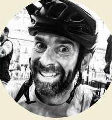 Smiling bearded man wearing cycling helmet, black and white