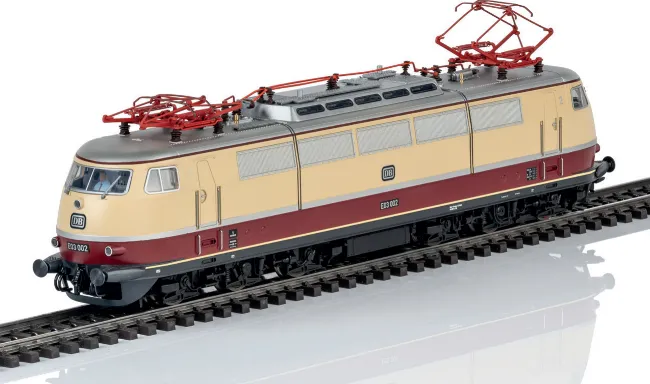Märklin/Trix model of the DB E03 electric locomotive in cream and red livery with pantographs raised, shown with matching coaches.
